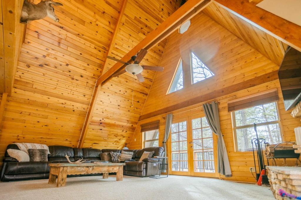 a living room in a log cabin with a vaulted ceiling at Furnished Deck + Fire Pit: Happy Jack Cabin in Happy Jack
