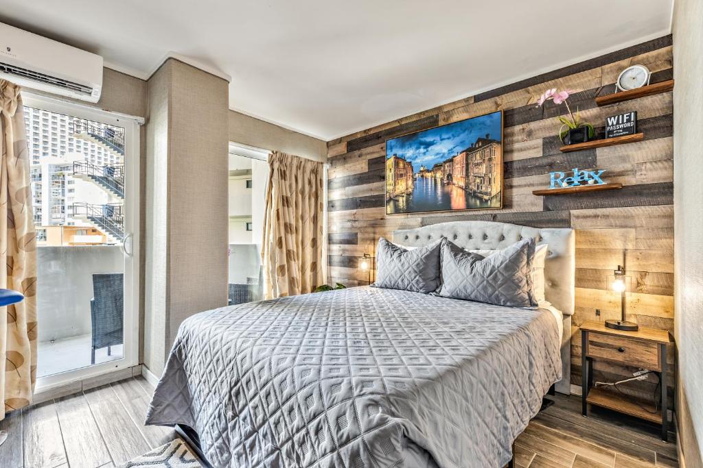 ein Schlafzimmer mit einem Bett und einer Holzwand in der Unterkunft Picturesque Hotel Room with Private Balcony in Waikiki! in Honolulu