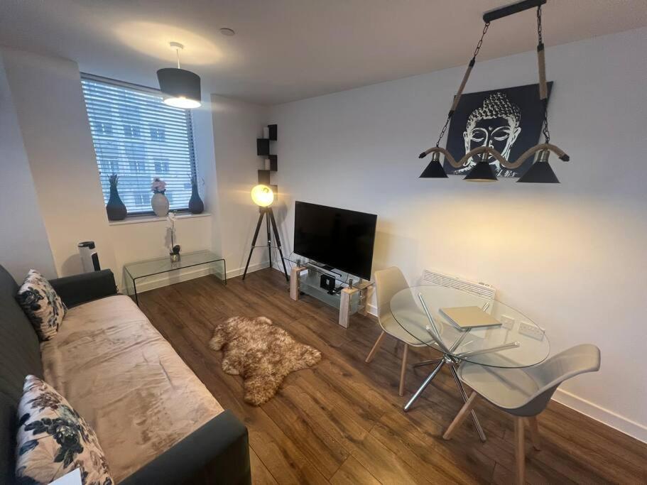 a living room with a couch and a glass table at Luxury Chic Apartments in Liverpool