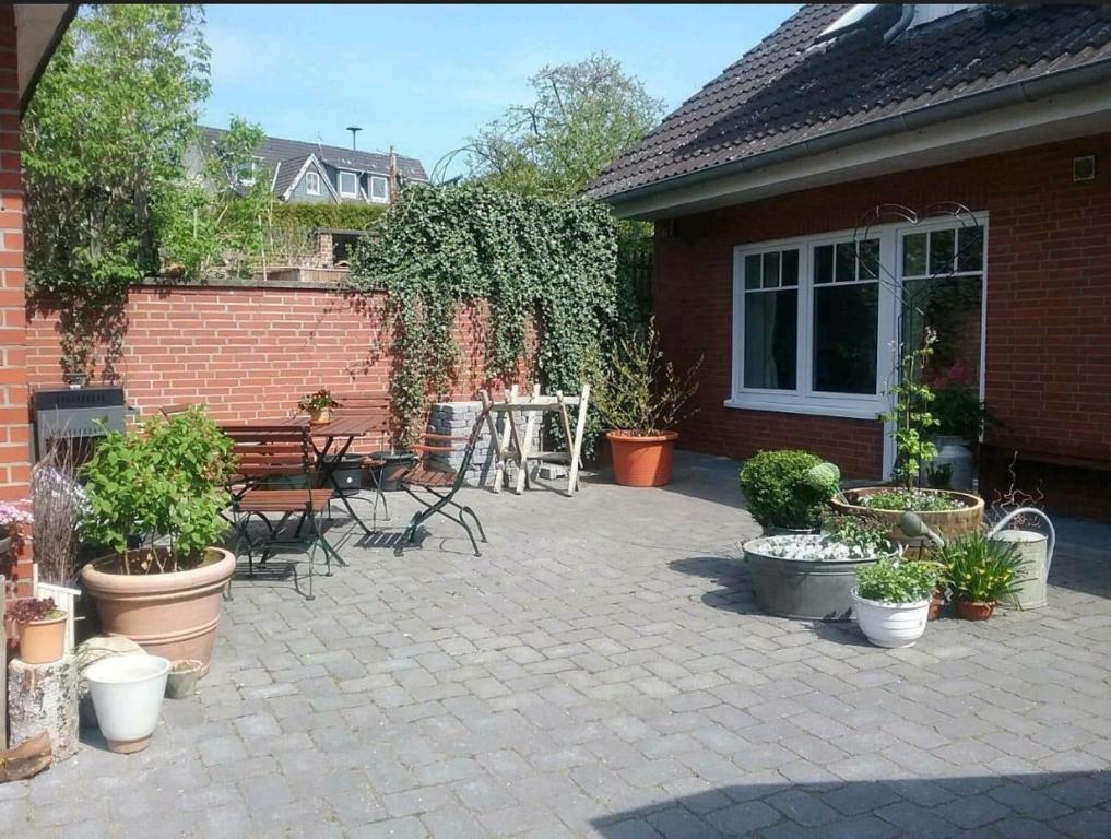 um pátio com vasos de plantas e uma mesa e cadeiras em Liebevoller Landhaustraum em Ratekau