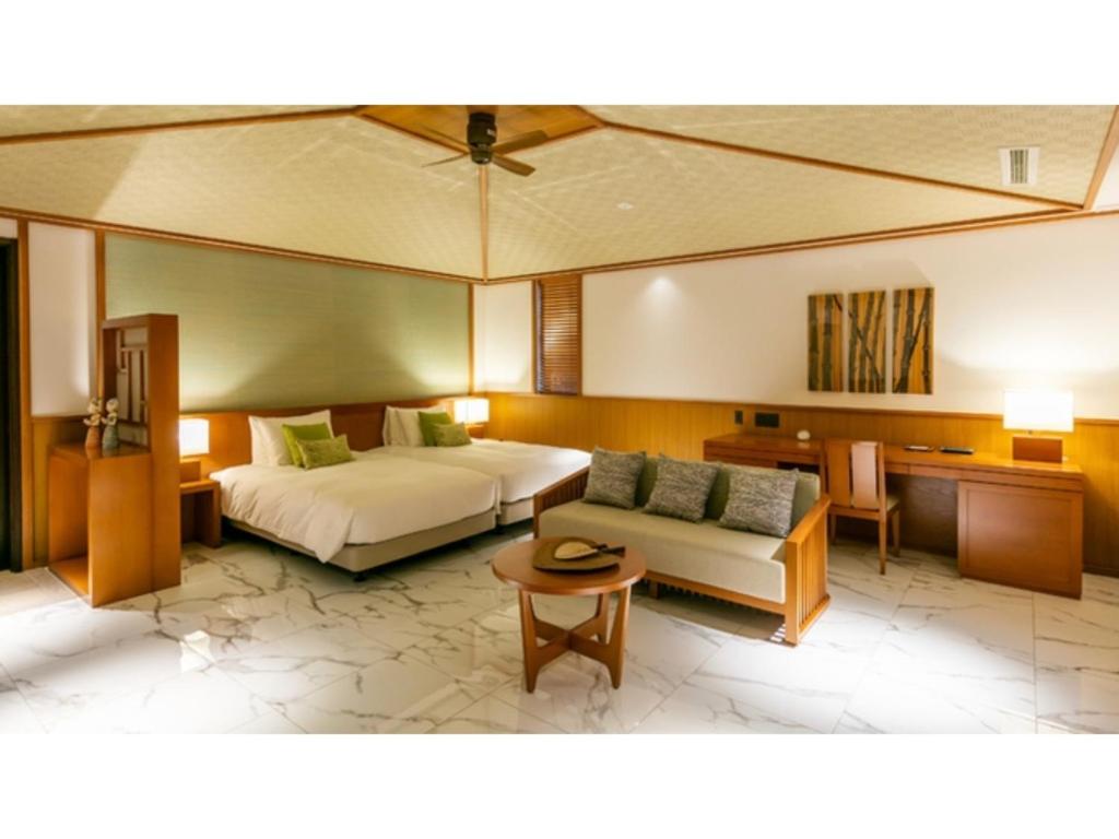 um quarto de hotel com uma cama e um sofá em Miyakojima Kurima Resort Seawood Hotel - Vacation STAY 16235v em Uechi