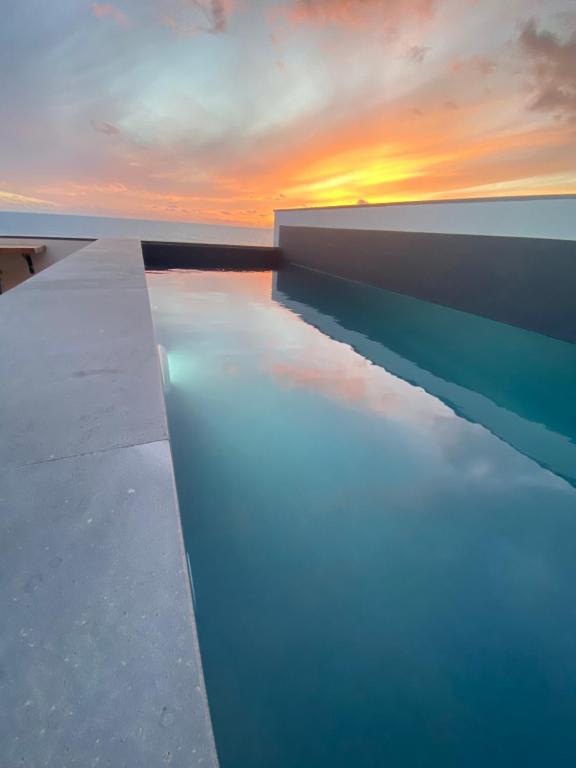 a view of the ocean with the sunset in the background at CASA DO SOL in Jardim do Mar