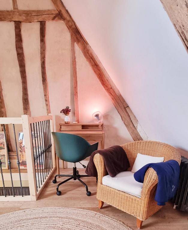 a living room with a chair and a desk at La Dragonne, petite maison au centre de Bellême, jardin, cuisine équipée, vue forêt in Bellême