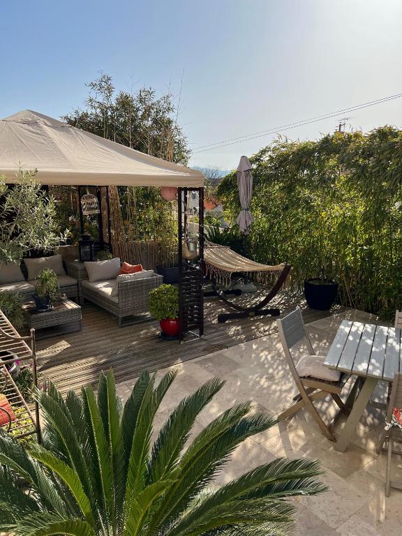 un patio avec une table, des chaises et un parasol dans l'établissement RDC de maison avec terrasse barbecue, à Toulon
