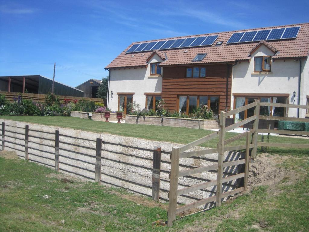 a house with solar panels on the roof at Cames Mead Farmhouse Bed and Breakfast in Mare Green