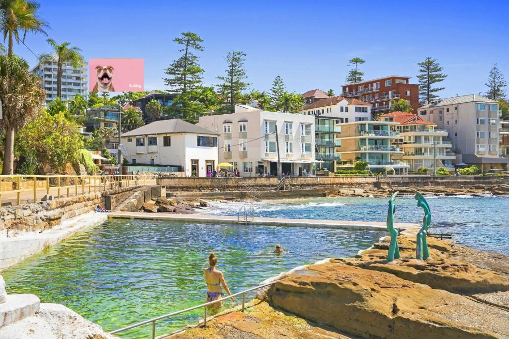 a woman standing in the water in a swimming pool at Marine Parade in Sydney