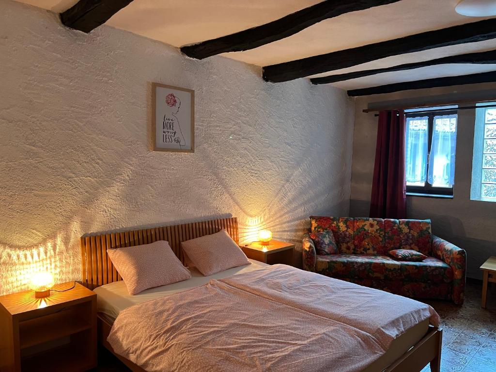 ein Schlafzimmer mit einem Bett, einem Stuhl und zwei Lampen in der Unterkunft Casa Dora in Brusino Arsizio
