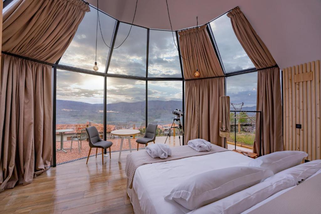 1 dormitorio con 1 cama y grandes ventanas de cristal en Glamping El Regajo Valle del Jerte en El Torno