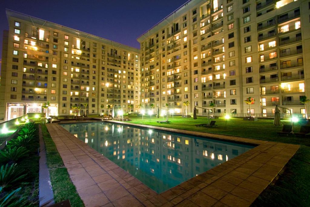 a swimming pool in front of a building at night at WeStay Westpoint Apartments in Johannesburg