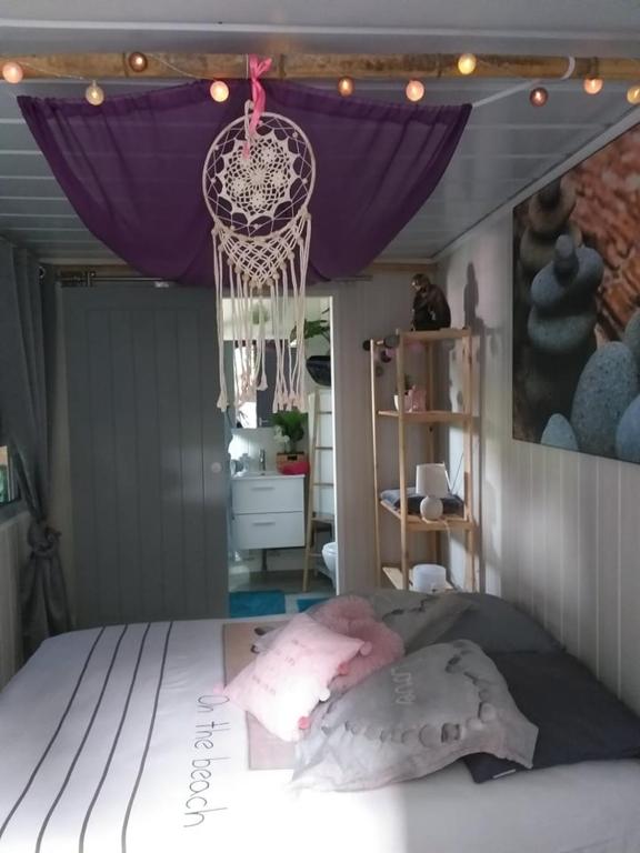 - une chambre avec un lit à baldaquin pourpre dans l'établissement LE REFUGE ZEN HEBERGEMENT ATYPIQUE A LA SEMAINE AVEC BUNGALOW, CABANE, BULLE ET SPA, à Montpouillan