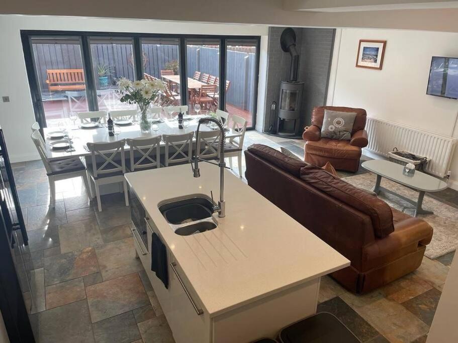 uma cozinha e sala de estar com um sofá e uma mesa em Luxury Portrush Holiday Homes - The Glynn, Portrush Sleeps 12 - 5 bedrooms em Portrush