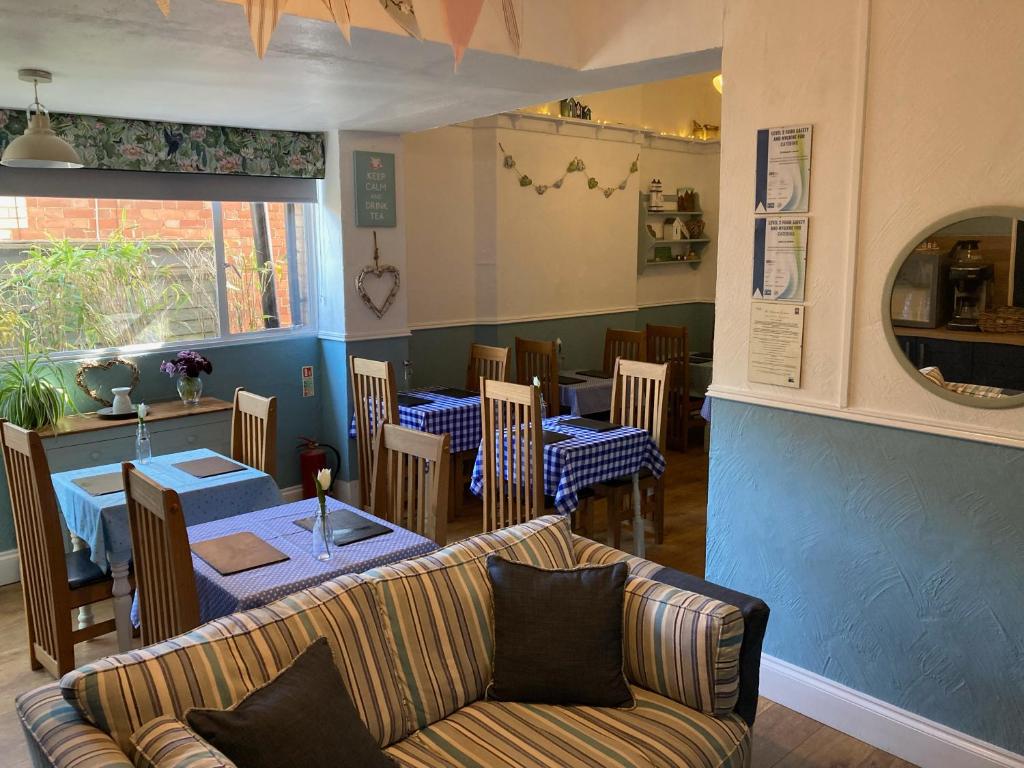 a restaurant with a couch and a table and chairs at The Wentworth Guest House in Paignton