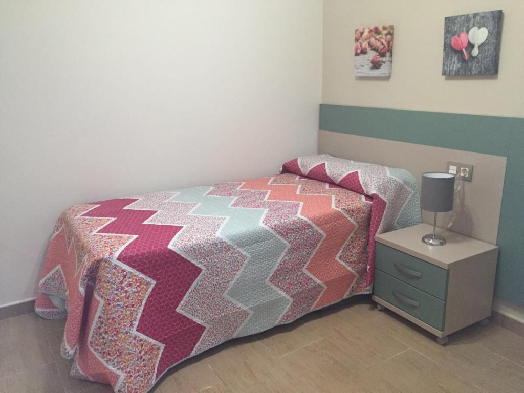 sypialnia z łóżkiem i stołem z lampką w obiekcie Apartamento Loyola Tania w mieście Conil de la Frontera