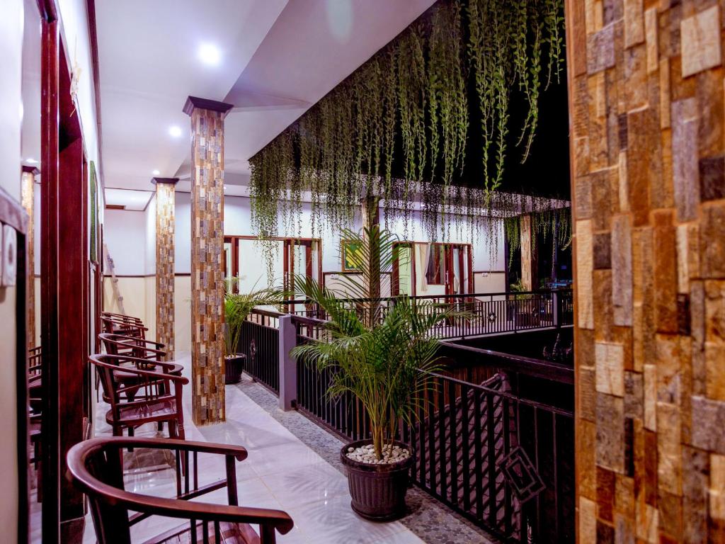 un restaurante con sillas y plantas en un balcón en Bali Laksita Homestay en Canggu