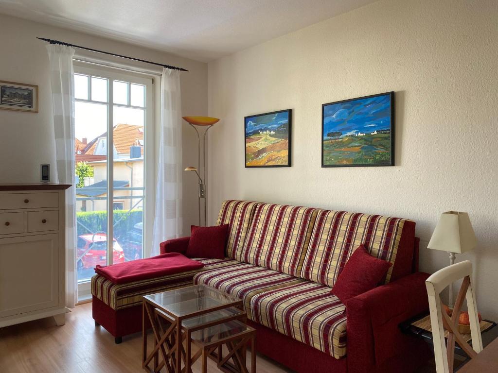 uma sala de estar com um sofá e uma mesa em Ulmenschlößchen Wohnung 09 em Kühlungsborn