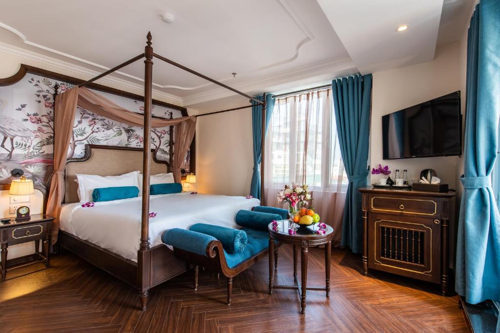 1 dormitorio con cama con dosel y mesa en Hanoi Tirant Hotel, en Hanói