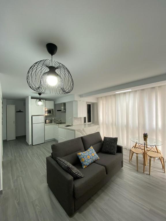salon z brązową kanapą i kuchnią w obiekcie Molineros Victoria Beach w Kadyksie