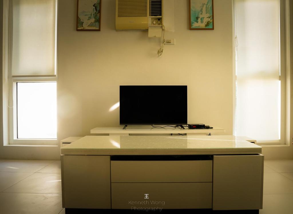 een kamer met een bureau en een tv. bij Pico de Loro Cove Hamilo Coast, Apartment 519, Corner Studio Unit, Jacana B Condominium in Nasugbu