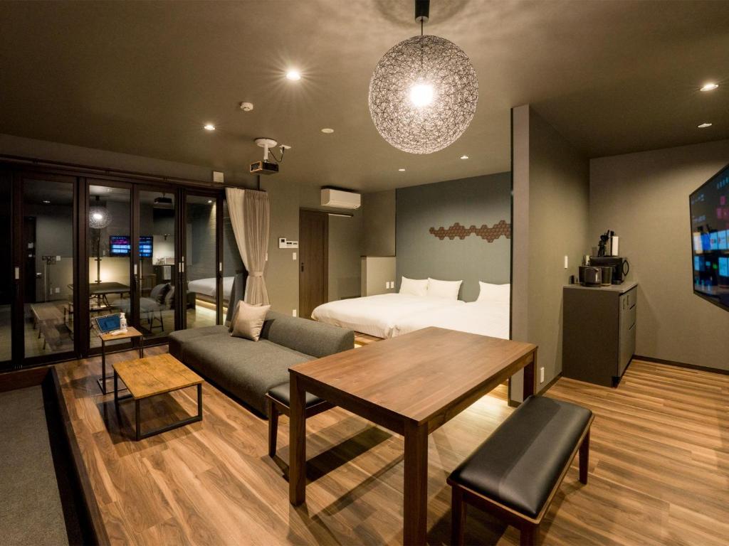 日光市にあるRakuten STAY Nikko Hoden Capacity of 4 personsのベッド、テーブル、ソファが備わる客室です。