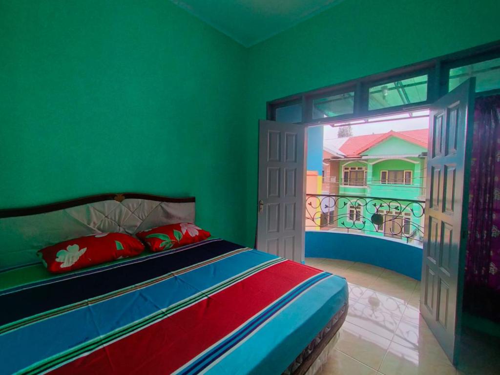 ブラスタギにあるVilla Gunung Mas Blok E No 3 A Berastagi Viewのベッドルーム1室(壁に絵画が描かれたベッド1台付)
