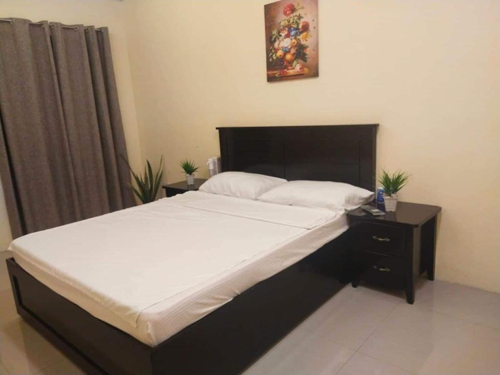 a bedroom with a large bed with a black headboard at RedDoorz @ KBL Transient Inn San Fernando in San Juan