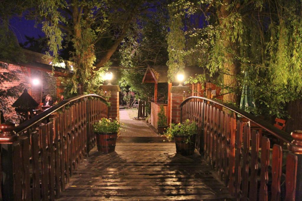 a walkway with potted plants on a fence at night at Penzion Uno in Hradec Králové