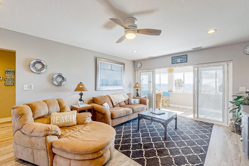 a living room with two couches and a ceiling fan at Isle of View in Mexico Beach
