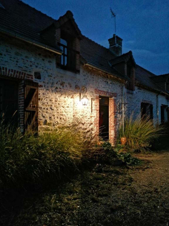 an old brick building with a light on the side at L&#39;auberge 10 à 15 pers 30min zoo beauval chambord cheverny in Langon