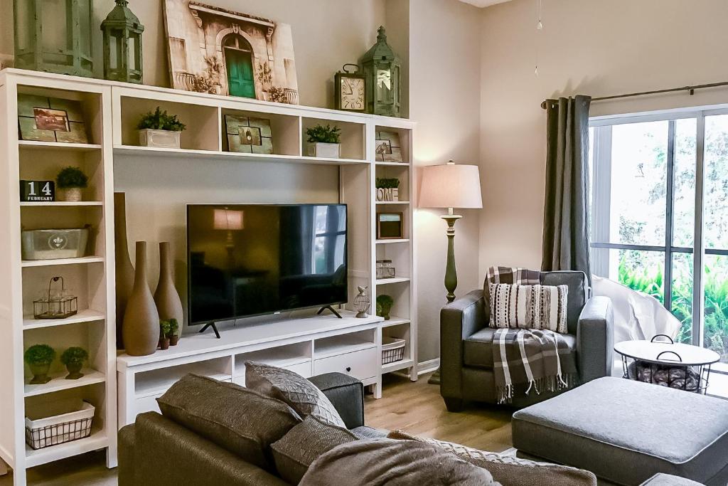 Una sala de estar con un sofá y un televisor. en Bahama Bay Resort 18702, en Kissimmee