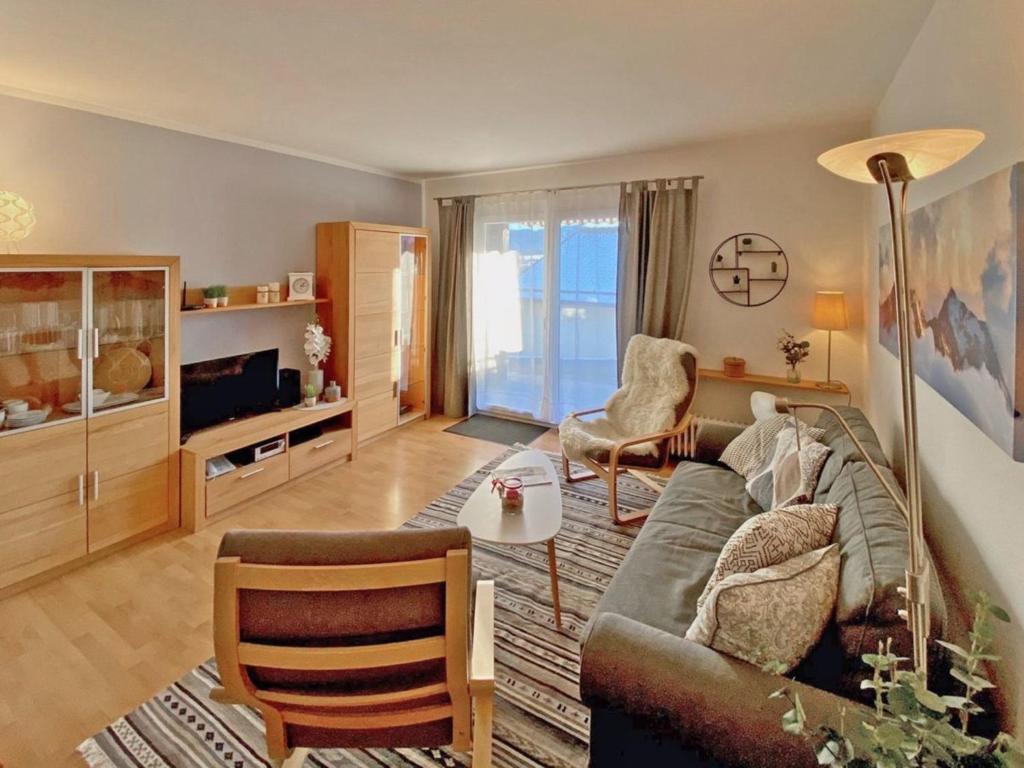 un salon avec un canapé et une table dans l'établissement Ferienhaus Nr 30, Kategorie Komfort Plus, Feriendorf Hochbergle, Allgäu, à Lechbruck am See
