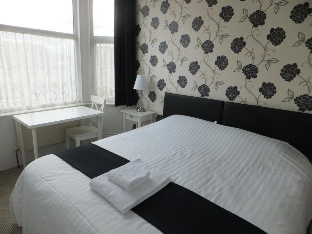 1 dormitorio con cama blanca y ventana en Grove Guest House en Nottingham