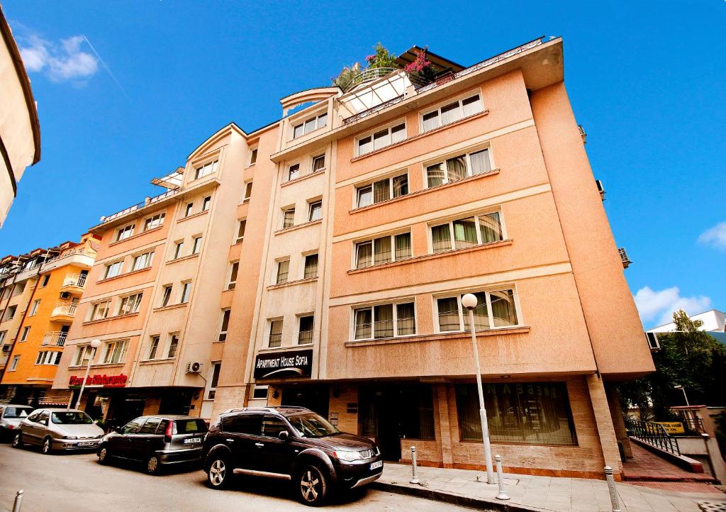 a tall building with cars parked in front of it at Sofia hotel apartments in Sofia