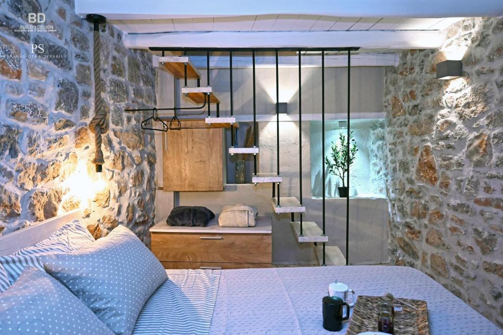 sypialnia z łóżkiem i kamienną ścianą w obiekcie Pyrgos Houses and Restaurant w mieście Avgonyma
