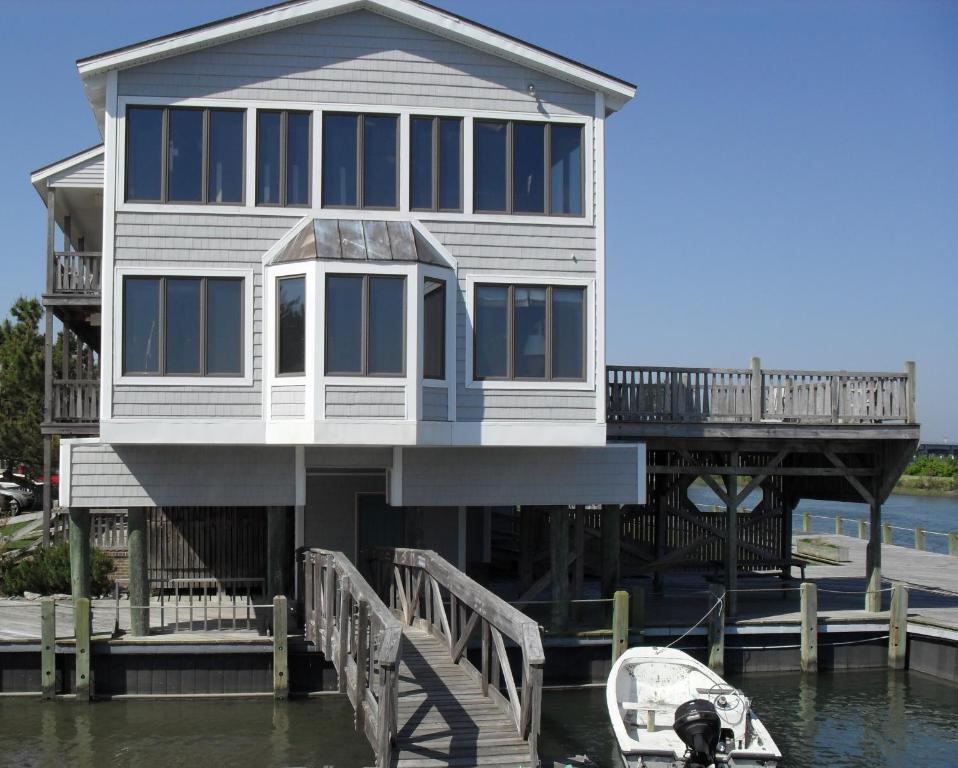 a house on a dock with a boat on the water at Island Resort in Chincoteague