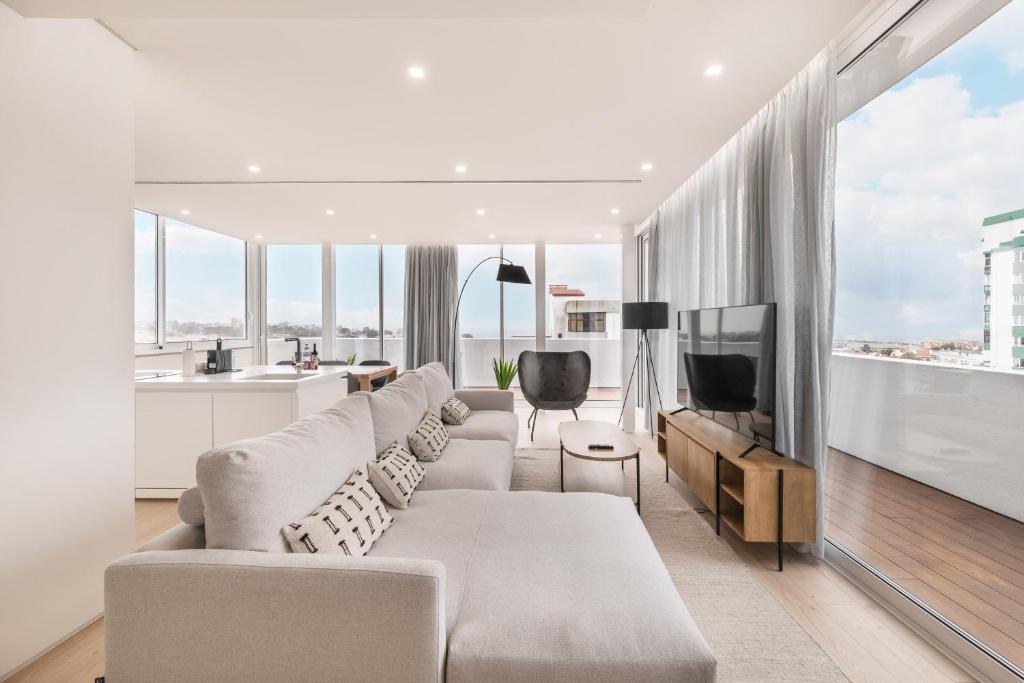 Una sala de estar con un sofá y un televisor. en Bay View Penthouse by Olala Homes, en Cascais