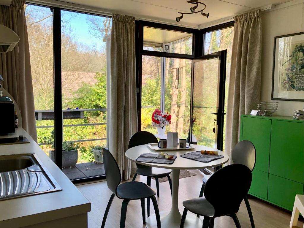 a kitchen with a table and chairs in front of a window at Linden-Jachthoorn in Lubbeek