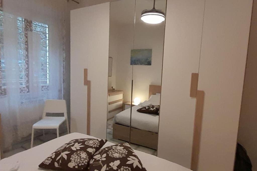 um pequeno quarto com uma cama e uma cadeira em Appartamento a due passi da Piazza del Campo em Siena