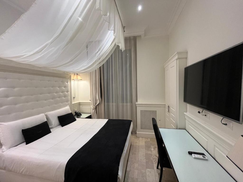 een slaapkamer met een groot bed en een televisie bij Hotel dei Quiriti Suite in Rome
