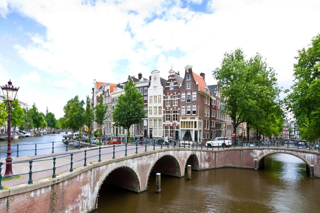 un puente sobre un río en una ciudad con edificios en Crown Hotel en Ámsterdam