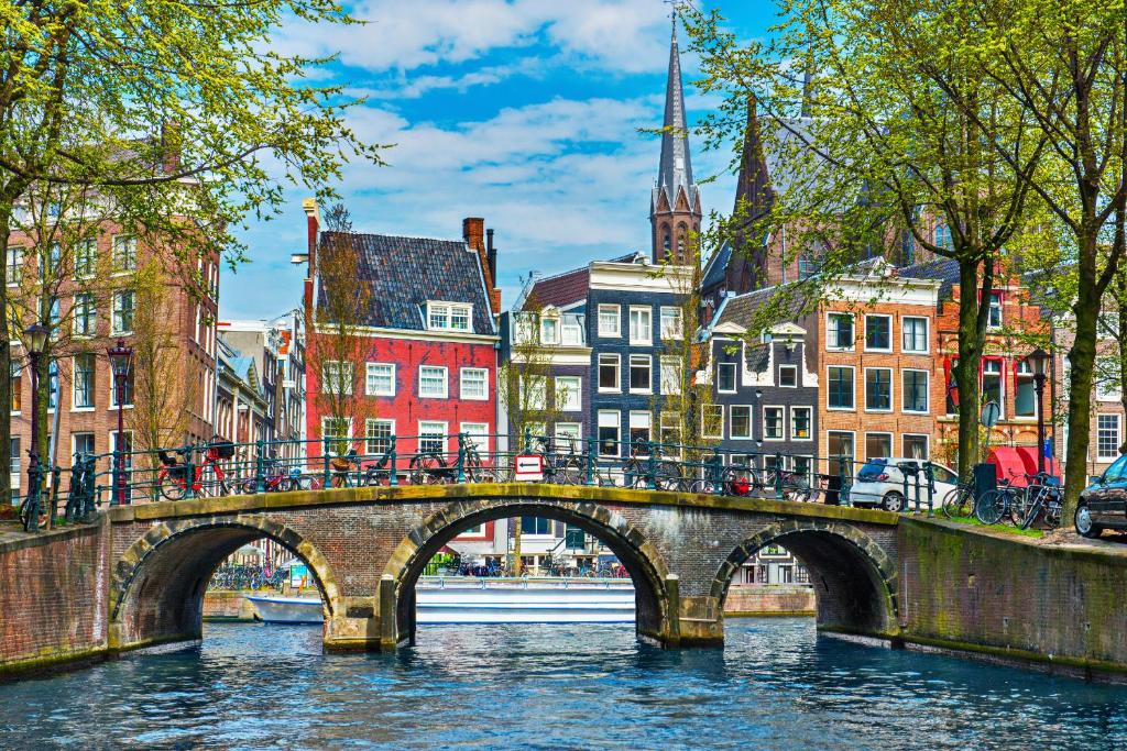 a bridge over a river in a city with buildings at The Crown Hotel in Amsterdam