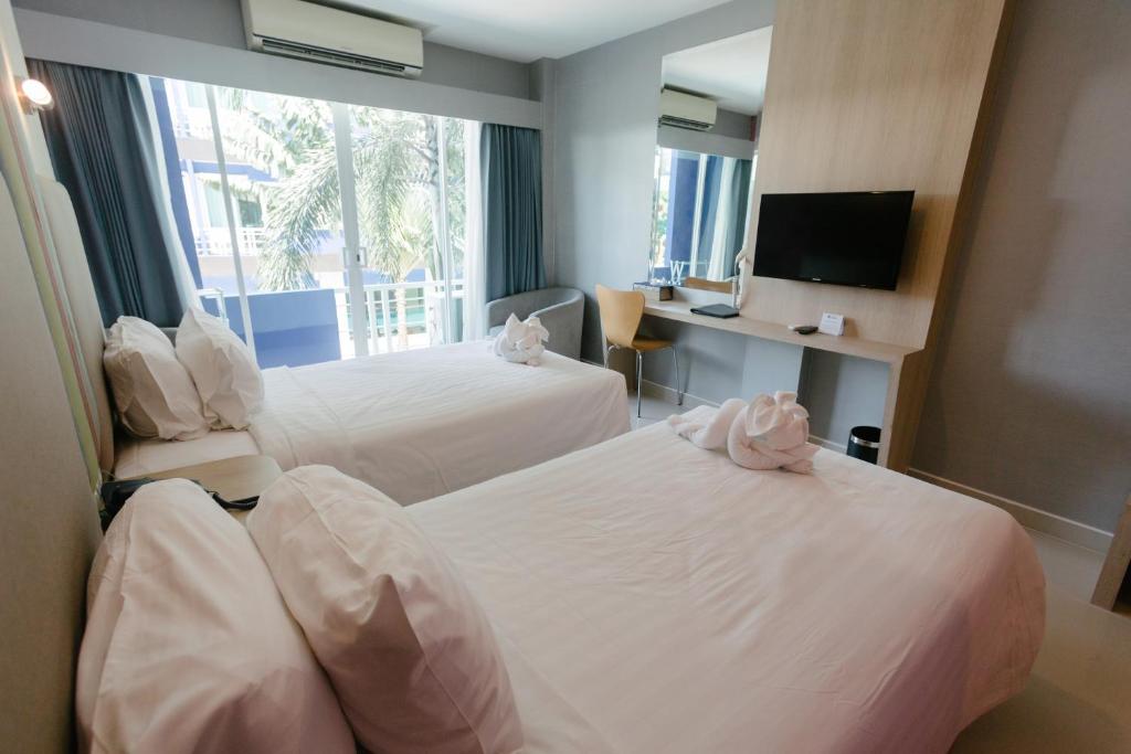 a hotel room with two beds and a television at Best Western Royal Buriram in Buriram
