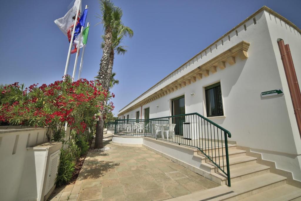 un edificio con escaleras y una palmera en Residence Cala Verde, en Marina di Mancaversa