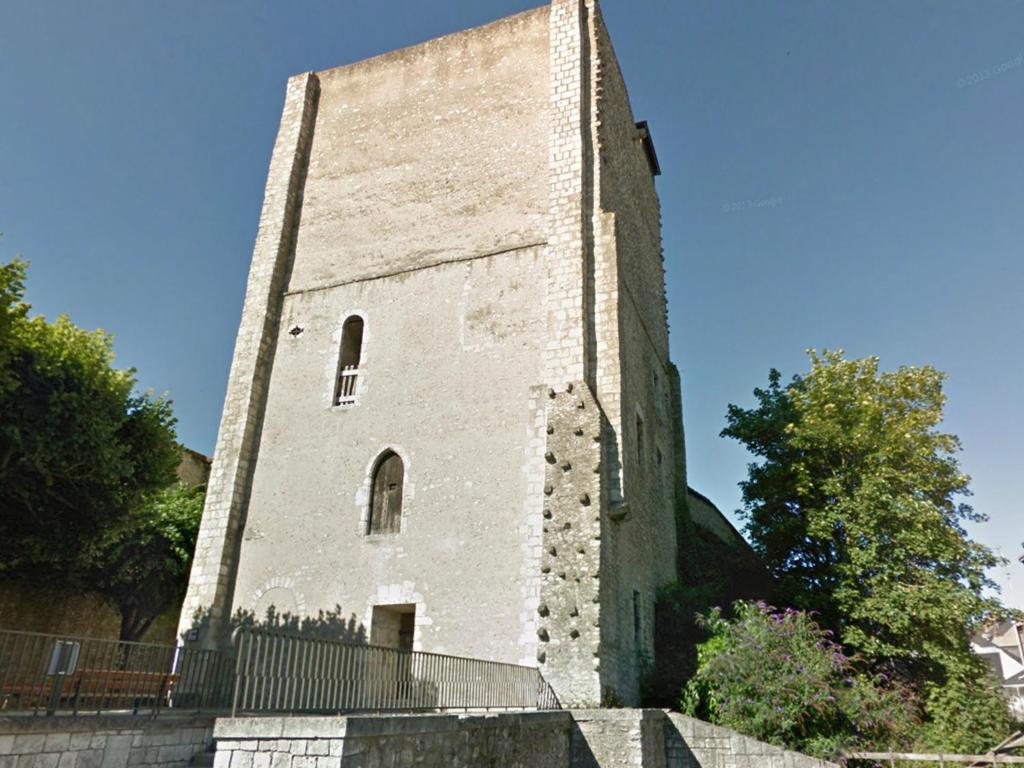 un edificio de ladrillo alto con una valla alrededor en La Tour Beauvoir, en Blois