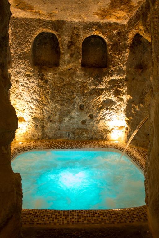 a pool of blue water in a stone cave at Casa Spa La Agueda y Robledo in Peñaflor
