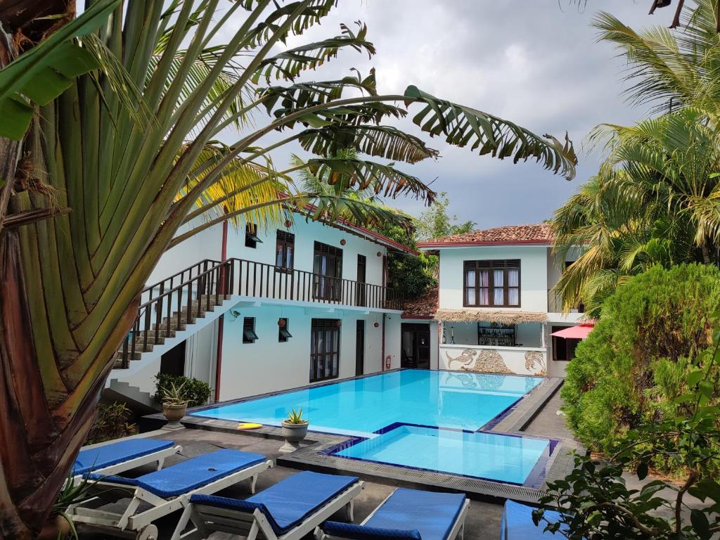 una piscina frente a una casa con tumbonas en Villa Tangalle Lagoon, en Tangalle