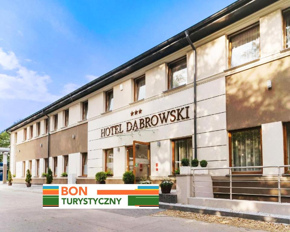 オシフィエンチムにあるHotel Dąbrowskiの目の前に看板が立つホテルの建物