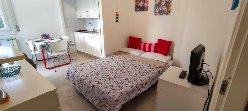um pequeno quarto com uma cama com almofadas vermelhas em La Palma em Rapallo