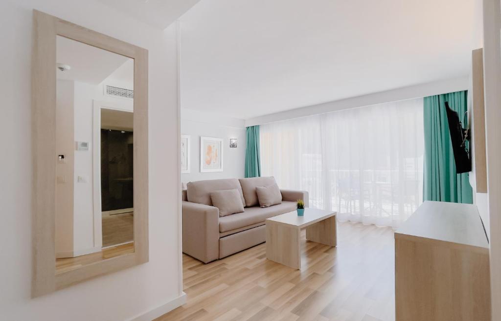 a living room with a couch and a mirror at Comitas Floramar in Cala Galdana