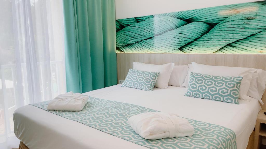 a bedroom with a bed with two pillows on it at Comitas Floramar in Cala Galdana