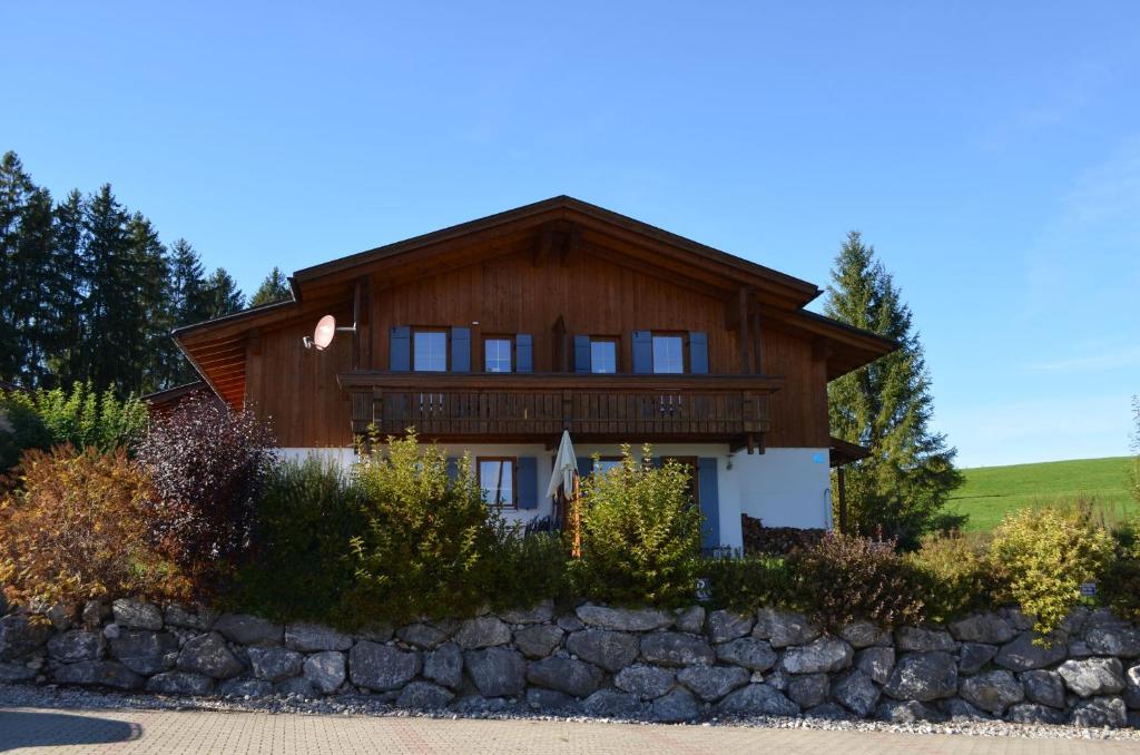 uma grande casa de madeira com uma parede de pedra em Feriendorf Via Claudia Haus 100 Dominique em Lechbruck